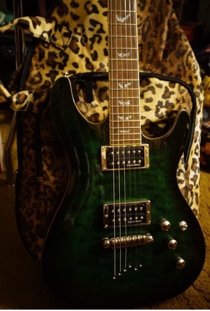 Custom green electric guitar with leopard case